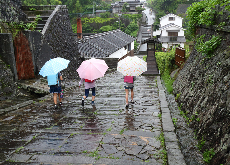 傘をさして歩く子どもたち